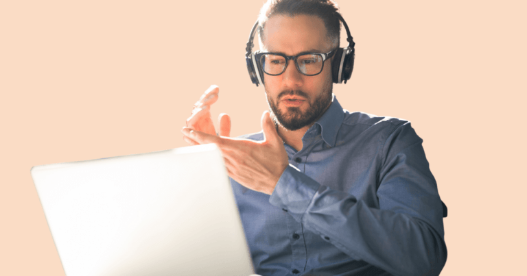 Hombre joven con auriculares mirando atentamente la pantalla de un ordenador, sugiriendo una videollamada o sesión de terapia online.