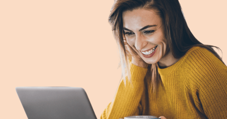 Una chica joven con una taza en la mano, sonriendo levemente mientras mira la pantalla de un ordenador, sugiriendo una conexión online positiva.