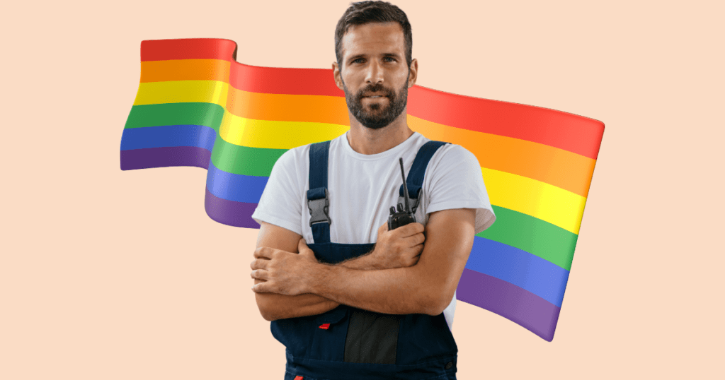 Trabajador con mono de trabajo y camiseta blanca, sosteniendo un walkie-talkie, con la bandera LGTBIQ+ difuminada al fondo.