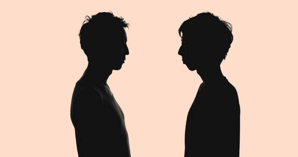 Dos siluetas oscuras de hombres, visibles de la cintura hacia arriba, de pie uno frente al otro.