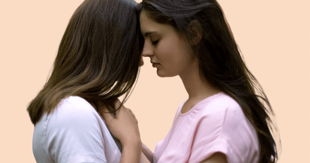 Dos mujeres en un plano cercano, tocándose suavemente de forma cariñosa, simbolizando la conexión, el placer y la intimidad segura.