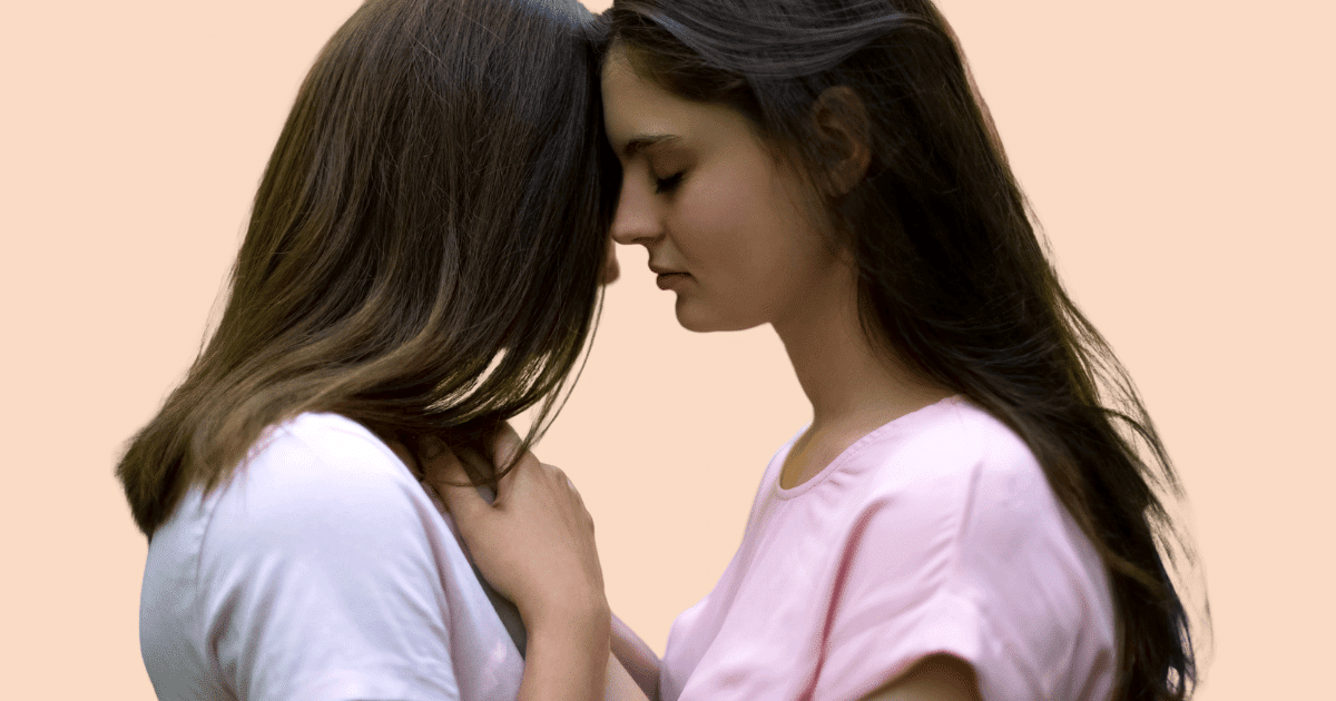 Dos mujeres en un plano cercano, tocándose suavemente de forma cariñosa, simbolizando la conexión, el placer y la intimidad segura.