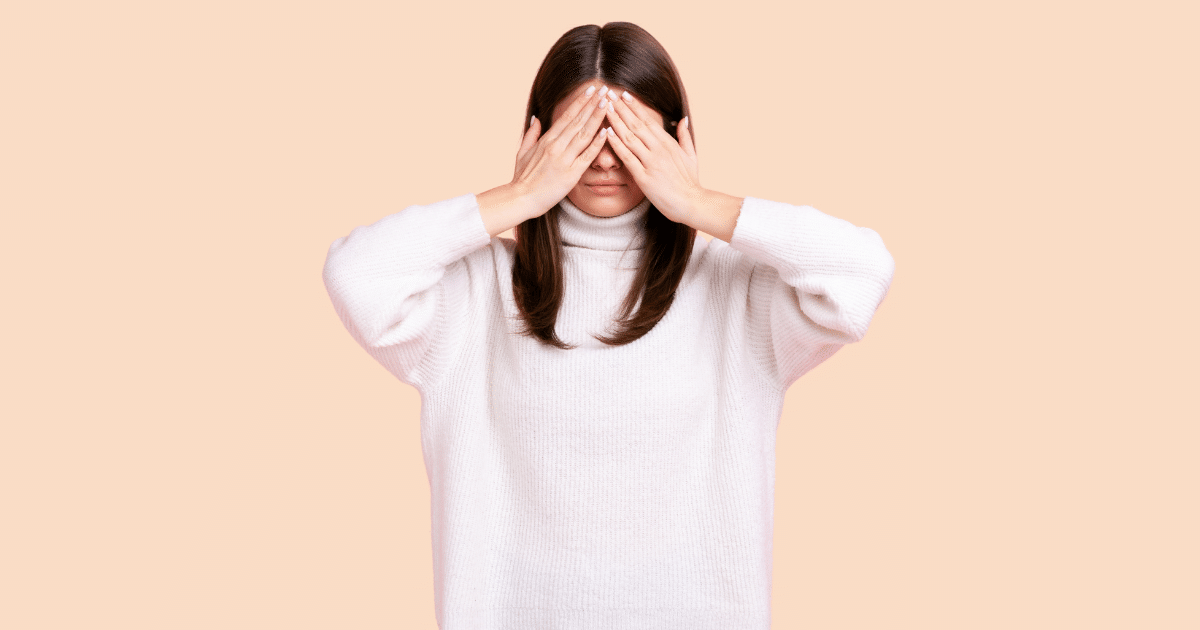 Una chica con las manos cubriendo sus ojos, en un gesto que simboliza la vergüenza, el ocultamiento o la incapacidad de verse a sí misma.